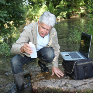 Biólogo testando a qualidade da água do riacho